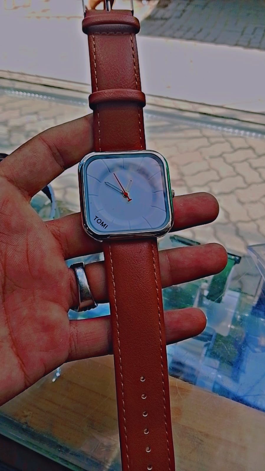 Tomi T-093 watch featuring a square dial and a brown leather strap.