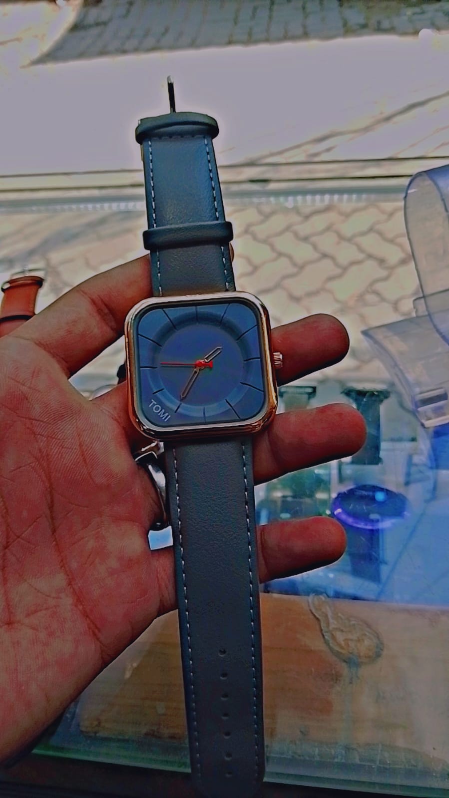 Tomi T-093 watch featuring a square dial and a black  leather strap.